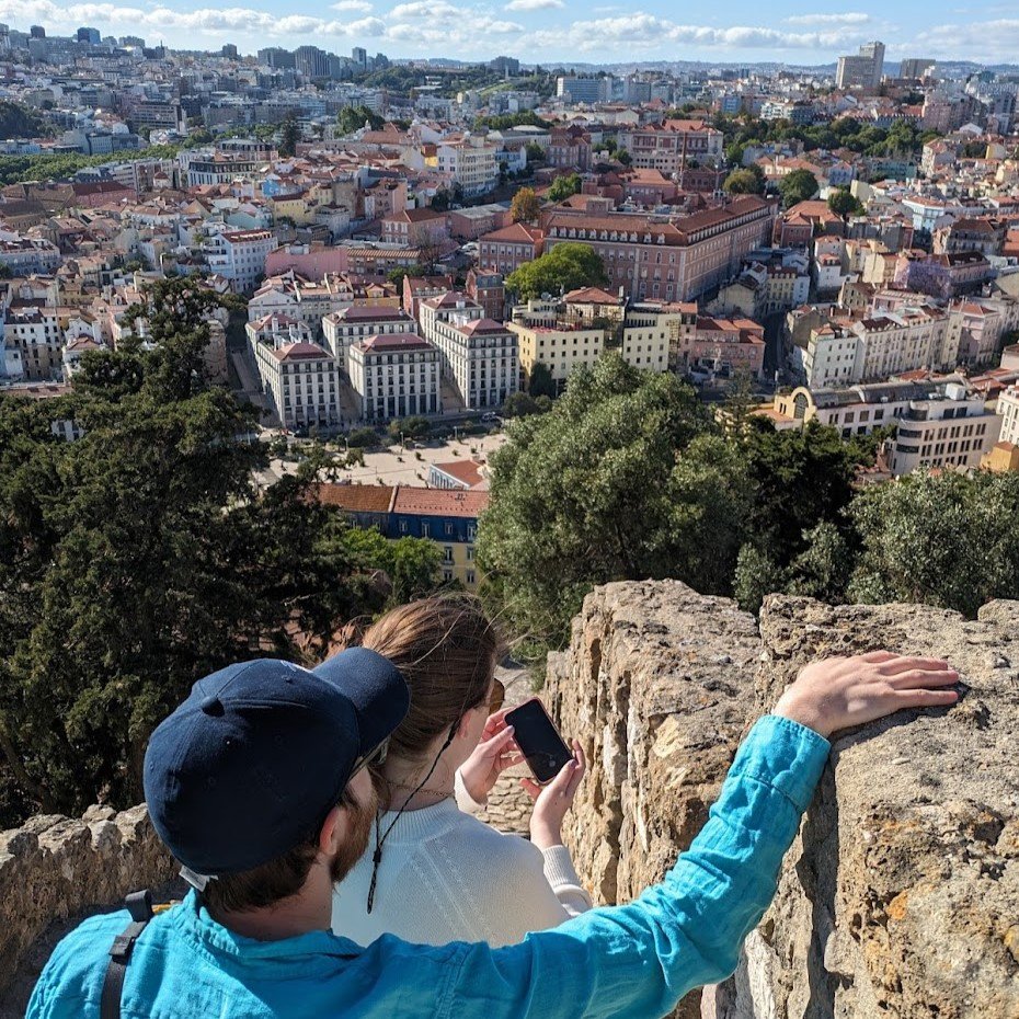 A couple look over Lisbon from the medieval walls on a walking tour.