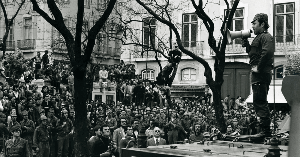 A man with a bullhorn speaks to a crowd in Largo de Carmo, one of the major locations of our Carnation Revolution History Tour.