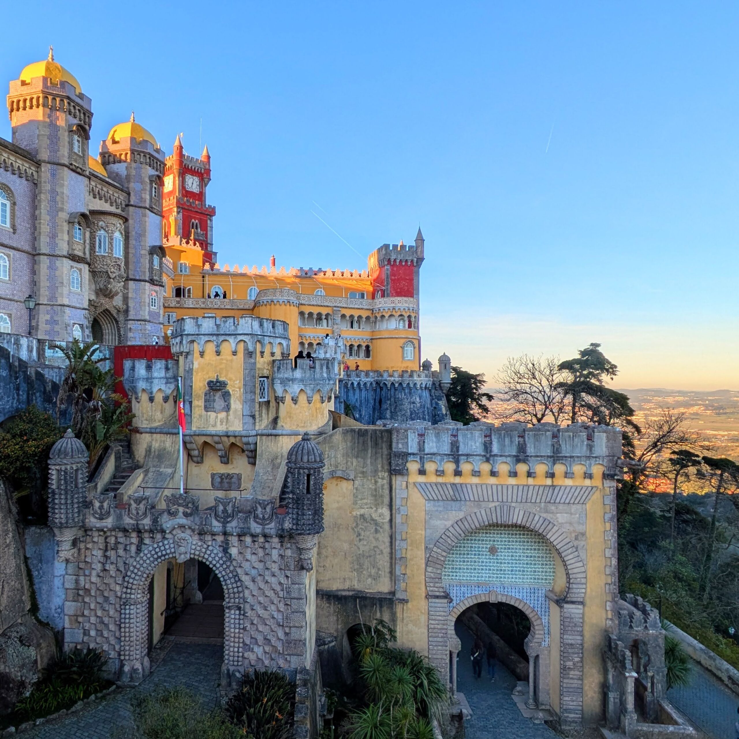 PXL_20260221_174510635-EDIT A view of Pena Palace, an ornate 19th century castle covered in tile, primary colors, and mildew.