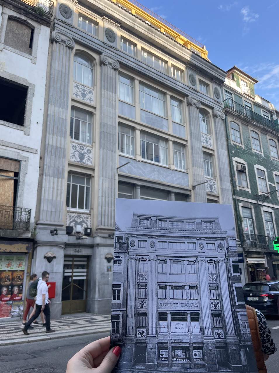 In the background, the Havas building as it stands today; in the foreground, a hand holds an image of how it looked to the Jewish refugees of the 1940s.