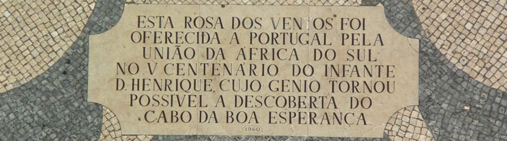 An image of the founding stone, reading: "Esta rosa dos ventos foi oferecida a Portugal pela união da Africa do Sul no V Centenário do Infante D. Henrique, cujo génio tornou possível a descoberta do Cabo da Boa Esperança. 1960."